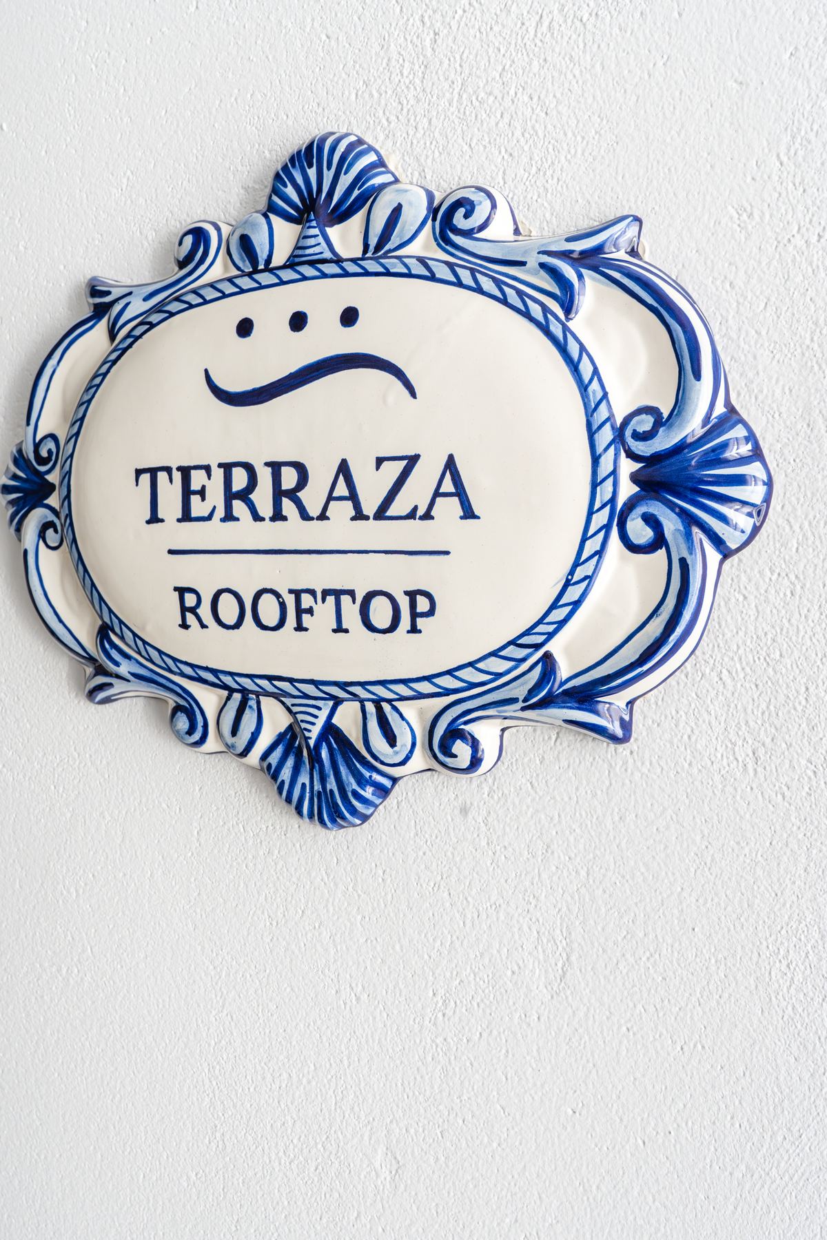 Placa de azulejo azul y blanco que indica la terraza