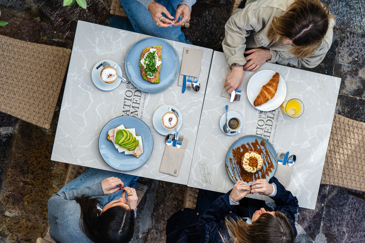 Desayuno completo visto desde arriba, con croissant, tostadas y zumo