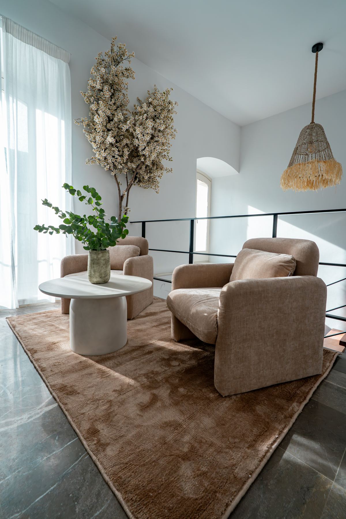 Sala de estar en la galería alta, con butacas y luz natural
